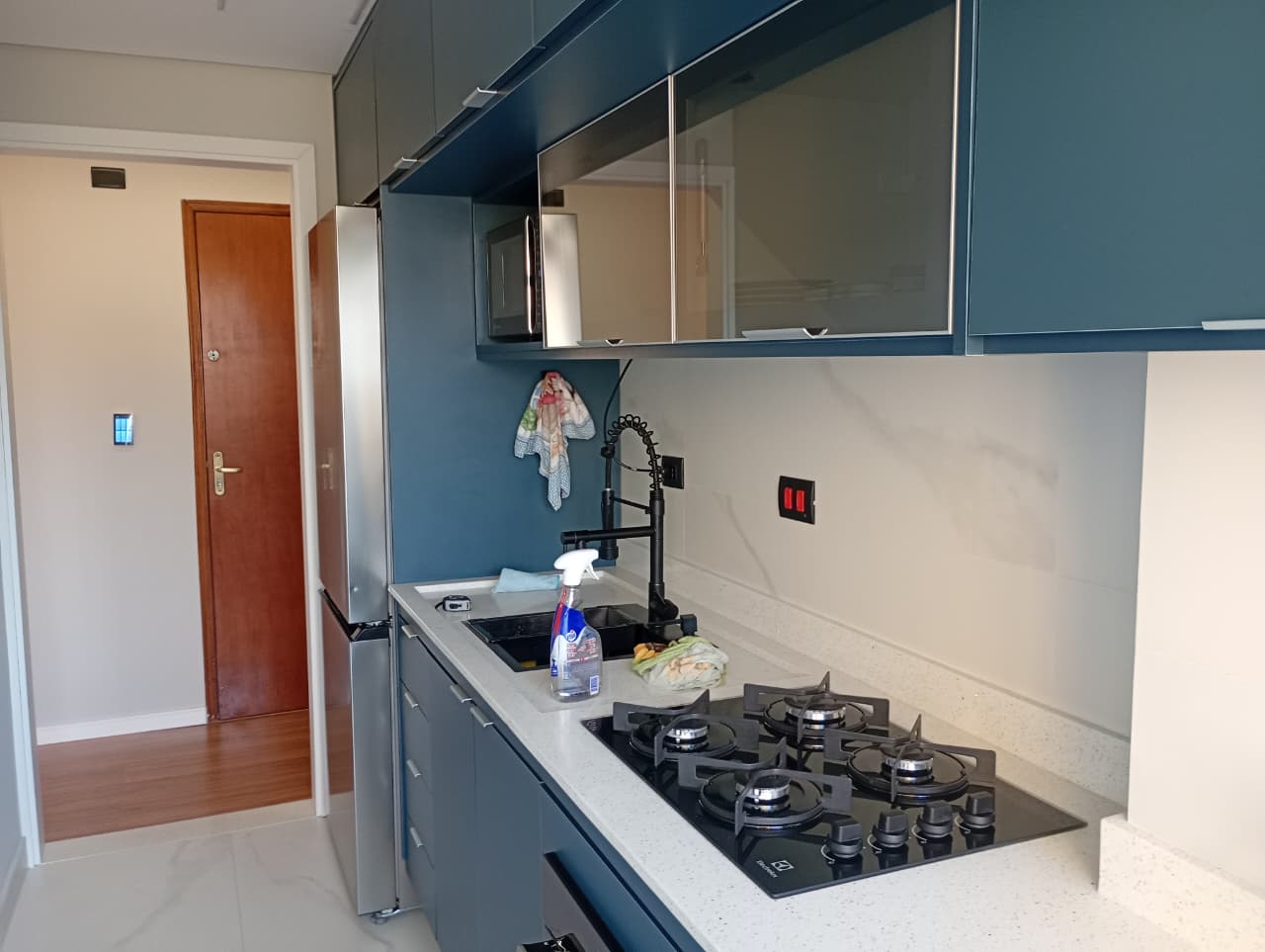 Cozinha com armários azuis e bancada clara