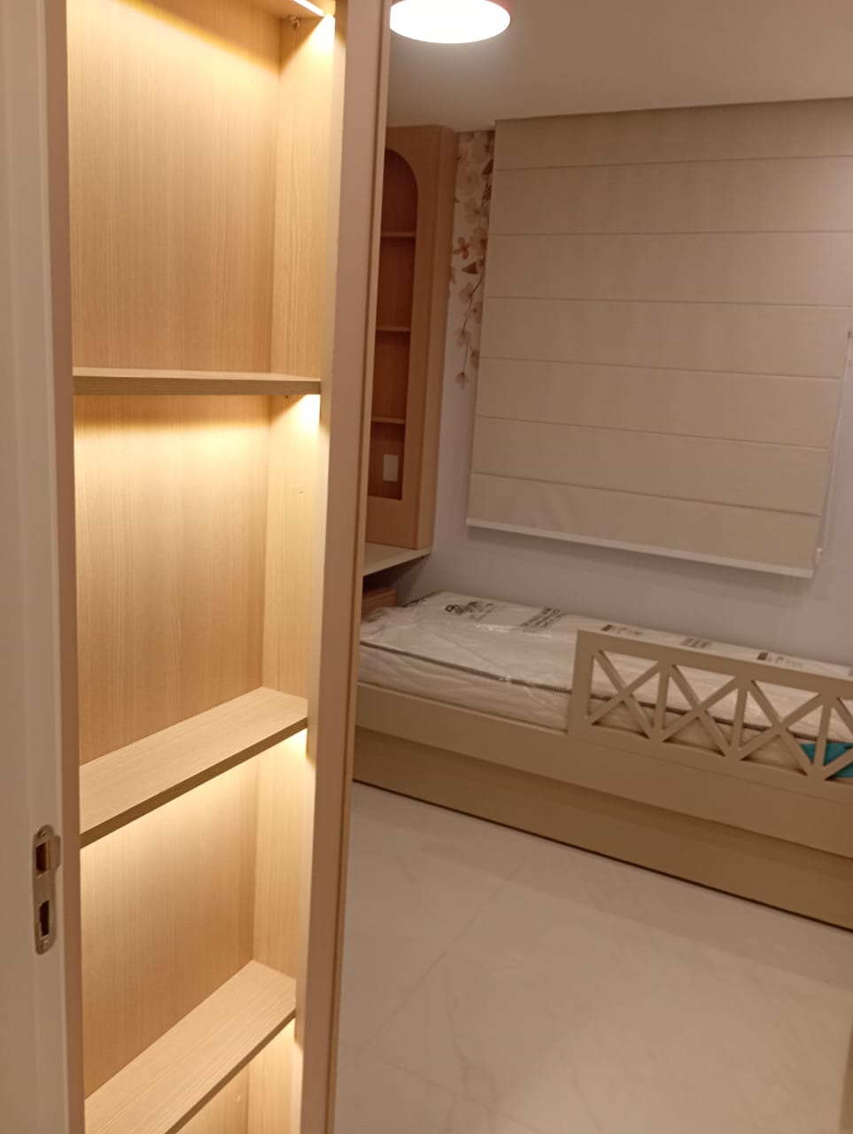 Quarto infantil com cama e nichos de madeira iluminados